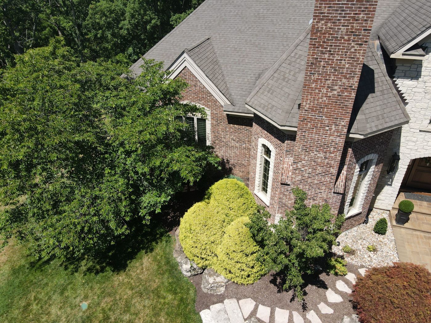 Roof repair on a brick home in St. Louis — new shingles and chimney flashing